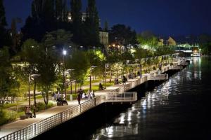 a bridge over a river at night with people on the sidewalk at Vichy Cocoon Appartements in Vichy