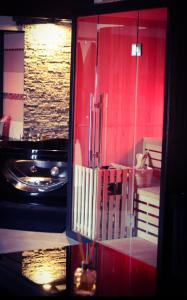 a reflection of a bathroom with a red wall at Loft 47 Spa in Chambly