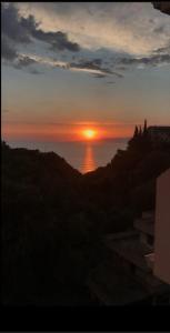 zachód słońca nad oceanem i słońce na niebie w obiekcie CASA IL TRAMONTO w mieście San Nicola Arcella