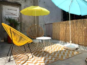 twee stoelen en een tafel met twee parasols op een terras bij Rainbow Central Studio by Carpe Diem in Zagreb