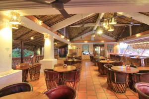 a restaurant with wooden tables and chairs at Bungalows Santa Cruz in Puerto Escondido