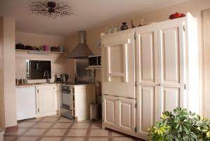 eine Küche mit weißen Schränken und einer Tür darin in der Unterkunft Entredigue in Divonne-les-Bains
