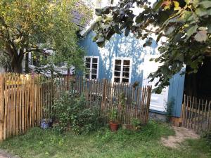 a blue and white house with a wooden fence at Sonnige Fachwerkwohnung in Alfter