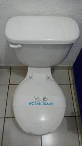 a white toilet in a bathroom with a sticker on it at Hotel Mirador Real in Bernal