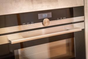 un forno chiuso con un orologio sopra di Ambassador Yellow Home a Grächen Altre 37 foto