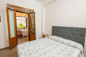 a bedroom with a bed and a window and a table at Stefanos Studios in Skala