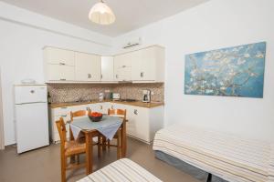 a kitchen and dining room with a table and chairs at Stefanos Studios in Skala