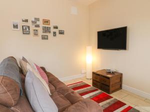 un salon avec un canapé et une télévision à écran plat dans l'établissement Church View Cottage, à Rugeley 5 autres photos