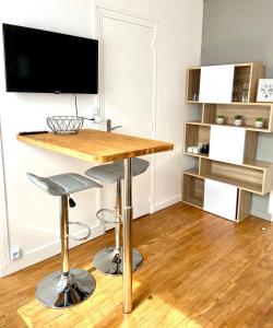 a living room with a table and a television at 6- Appartement de 2 pièces refait à neuf en centre ville in Dieppe