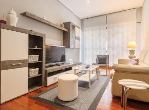 a living room with a couch and a tv at Prestancia Apartament by the Urban Hosts in Bilbao