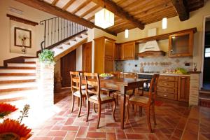 uma cozinha com uma mesa de madeira e cadeiras em Villa Farnetina em Cortona
