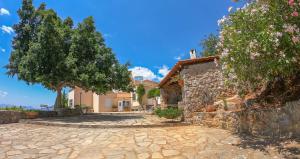 una casa con una entrada de piedra y árboles en Aloe Meli, en Kalamata