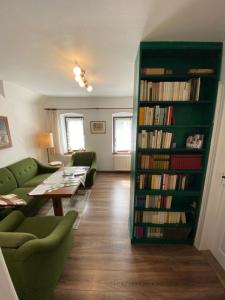 a living room with a book shelf filled with books at DIREKT AM SKIHANG! Müller Ferienwohnungen in Kurort Oberwiesenthal