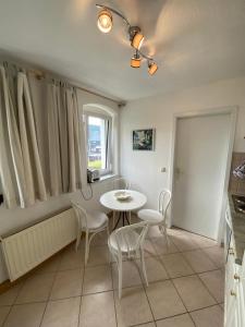 a kitchen with a table and chairs and a window at DIREKT AM SKIHANG! Müller Ferienwohnungen in Kurort Oberwiesenthal