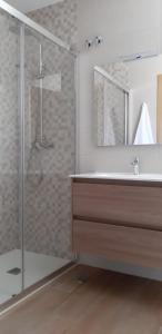 a bathroom with a sink and a shower with a mirror at Apartamentos Olimpo Celta-Apart Adriana in O Pindo