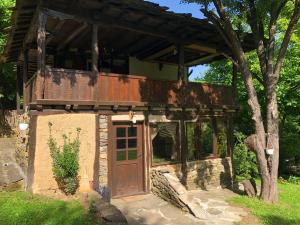a house with a wooden door and a tree at Etnographic Houses in Dŭlbok Dol
