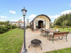 un patio avec un grill, une table et des bancs dans l'établissement Meadow View, à Saint Harmon