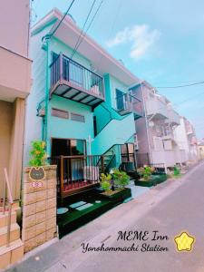 una casa azul al lado de una calle en MEME Inn与野本町駅前 en Saitama
