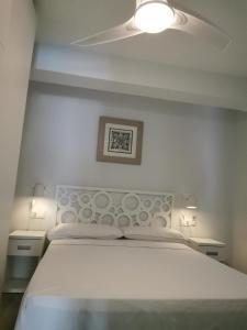 a bedroom with a white bed with a white headboard at Beach front Esther 3 Villajoyosa in Villajoyosa