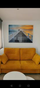 a couch in a room with a painting of a pier at Beach front Esther 3 Villajoyosa in Villajoyosa