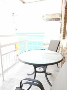 - une table et des chaises blanches dans une chambre avec fenêtre dans l'établissement Beach front Esther 3 Villajoyosa, à La Vila Joiosa