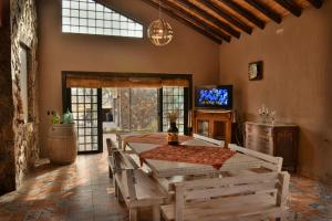 une salle à manger avec une table, des chaises et une télévision dans l'établissement CASA DISTINTA, à Mendoza