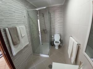 a bathroom with a toilet and a glass shower at House Fifteen in Horta