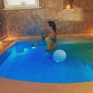 a young girl drinking water in a swimming pool at La mia suite farina in Ostuni
