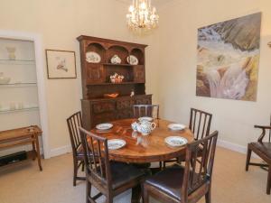 comedor con mesa de madera y sillas en 6 Ronald Place en Stirling