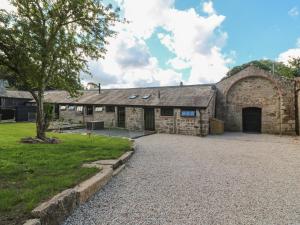 an old stone building with a tree in front of it at Nana's Cottage in Camborne