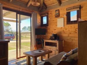 uma sala de estar com uma mesa e uma televisão numa cabina em Delfin em Punta Del Diablo