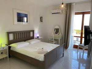 a bedroom with a bed and a table and a mirror at Villa Leucatia in Sant’Agata Li Battiati 
