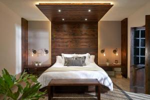 - une chambre avec un grand lit et une tête de lit en bois dans l'établissement H21 Hospedaje Boutique, à Mexico