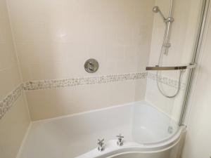 a bathroom with a shower and a tub with a sink at Driftwood in Filey +13 photos