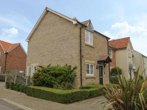 a brick house with white windows on a street at Driftwood in Filey