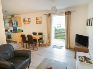 a living room with a table and chairs and a kitchen at Driftwood in Filey