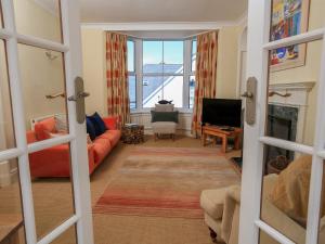 a living room with a red couch and a television at Wedgwood in Salcombe