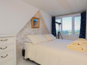 a bedroom with a white bed and a window at Wedgwood in Salcombe
