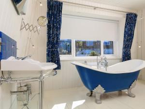 a bathroom with a blue tub and two sinks at Wedgwood in Salcombe +40 photos