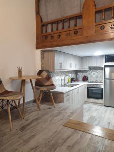 Melikarou houses في سكيروس: مطبخ مع دواليب بيضاء وطاولة وكراسي