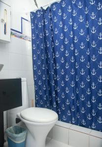 uma casa de banho com um WC e uma cortina de chuveiro azul em Beachfront Studio in Aguada em Aguada
