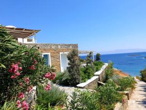 a house with a garden with flowers and the ocean at Simousea in Kithnos