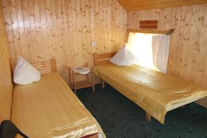 a small room with two beds and a window at Guest House Kalbakas in Smiltene