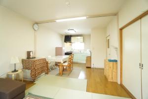 a living room with a table and a kitchen at Mark's HOME in Maebashi