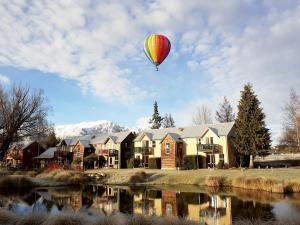 a hot air balloon is flying over a house at Millbrook Resort in Arrowtown