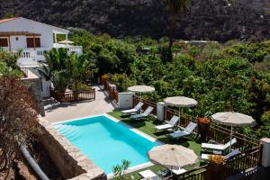 an external view of a villa with a swimming pool and umbrellas at Finca el Moral in Puerto de Mogán