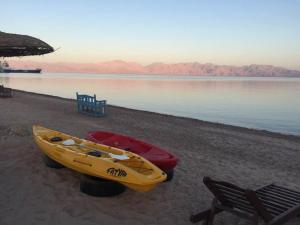 two boats sitting on a beach near the water at Sayadeen Village - Red Sea Riviera in Nuweiba