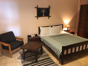 a bedroom with a bed and a chair and a chair at Sayadeen Village - Red Sea Riviera in Nuweiba