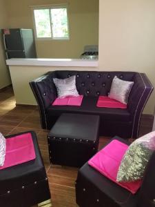 sala de estar con sofá y 2 reposapiés en FULA RIVER APARTMENT COTSY Eco en Bonao