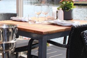een houten tafel met wijnglazen erop bij B&B Hotel Elselina in Schiedam